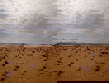 Brown sand under white clouds