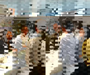 Six professionals standing around a table having a discussion