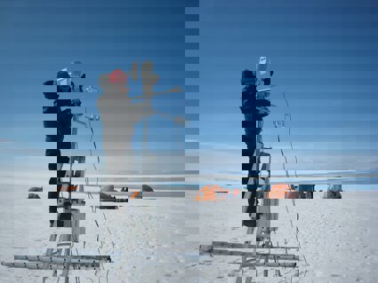 Person operating scientific equipment in polar environment.