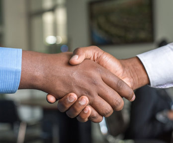 Two people shaking hands with only the hands in view. 
