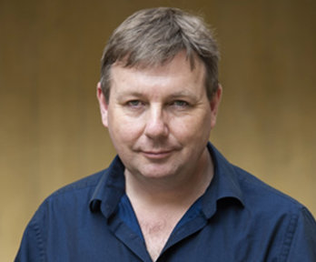 Headshot of a person wearing dark blue shirt.