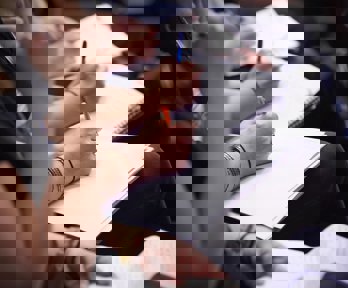 Seated people taking notes using notebooks