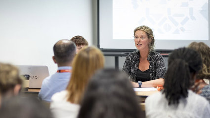 Discussion session at a conference, showing presenters and audience.