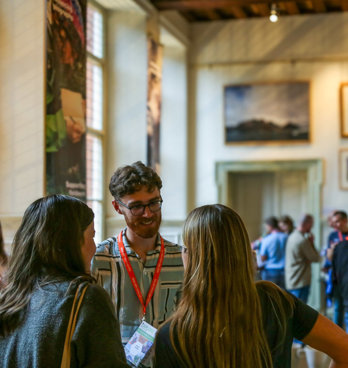 Conference attendees networking in the Main Hall at the Royal Geographical Society.
