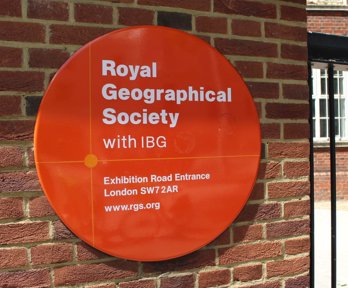 Orange welcome sign that reads Royal Geographical Society with IBG Exhibition Road Entrance.