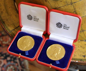 Two royal medals sitting on a floor globe.