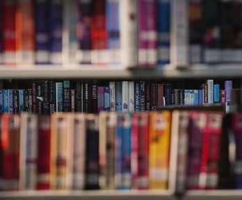 Colourful library books on a shelves.